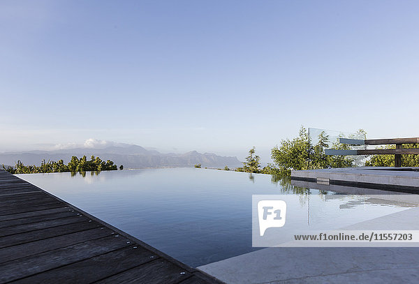 Ruhiger Luxus-Infinity-Pool mit Bergblick unter blauem Himmel