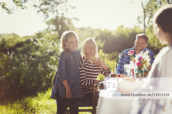 Happy family enjoying lunch at sunny garden party patio table
