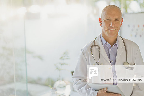 Portrait confident male doctor with digital tablet