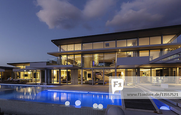 Beleuchtetes  modernes  luxuriöses Haus mit Swimmingpool bei Nacht.