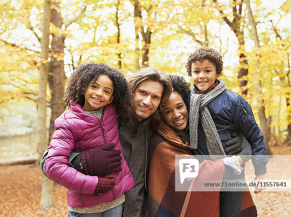 Portrait smiling young family in autumn park