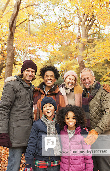 Portrait lächelnde Mehrgenerationen-Familie im Herbstwald