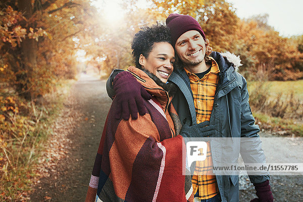 Lächelndes  liebevolles Paar  das sich im Herbstpark umarmt.