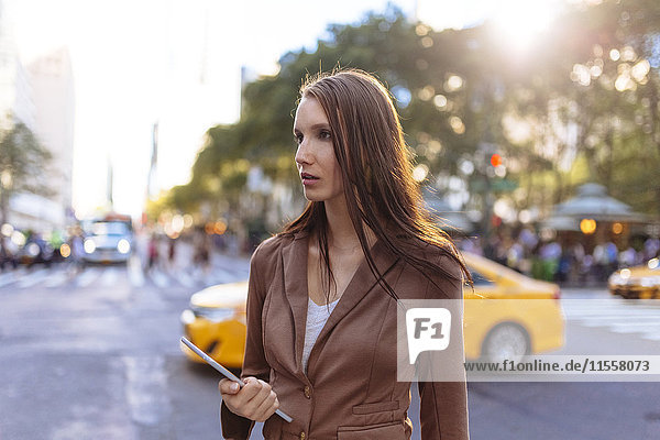 USA  New York  Manhattan  junge Geschäftsfrau mit Tablette  die etwas beobachtet.