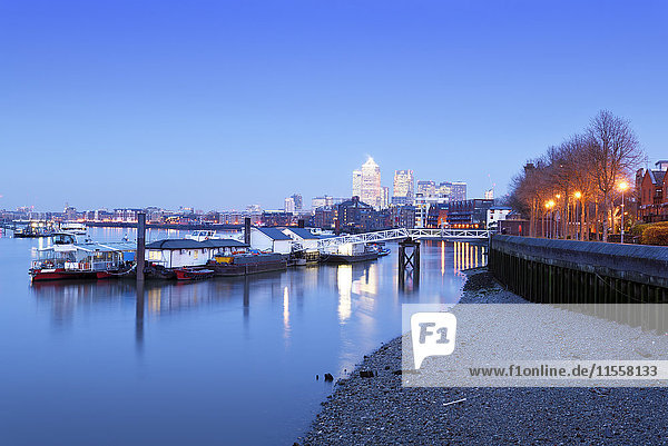 UK  London  schwimmende Workshops an der Themse und Canary Wharf im Hintergrund zur blauen Stunde