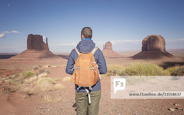 USA  Utah  back view of man with backpack looking at Monument Valley