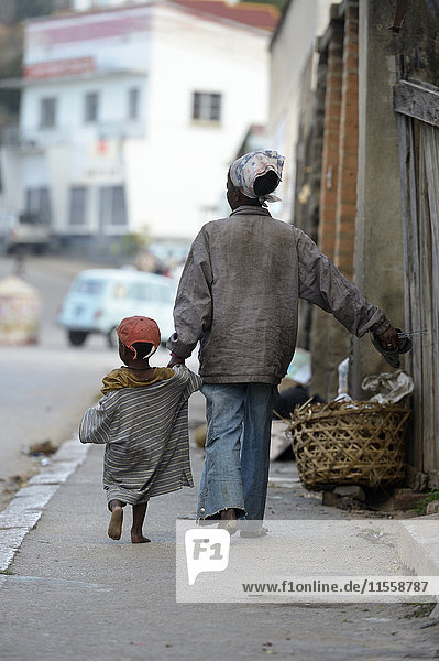 Madagascar  Fianarantsoa  Homeless mother with her child walking in the street