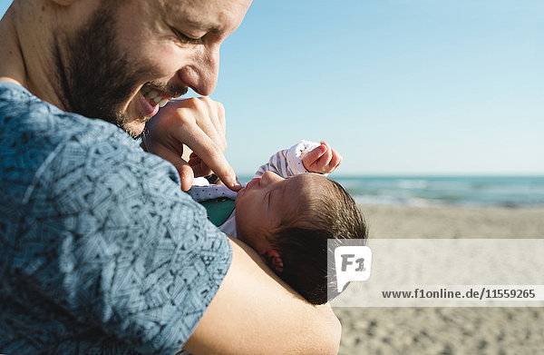 Vater mit seinem neugeborenen Mädchen am Strand