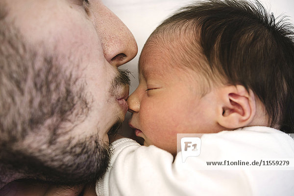 Father kissing his newborn baby girl