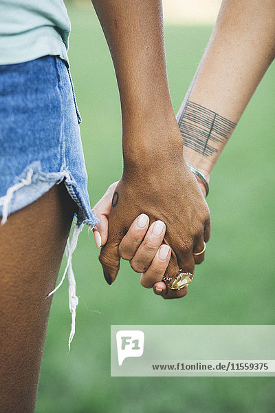 Two women holding hands in a park