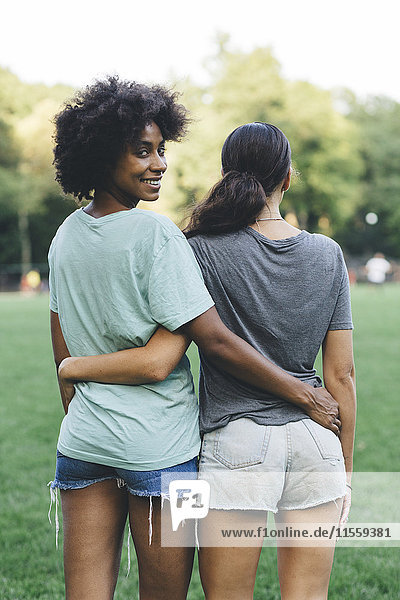 Two women arm in arm in a park