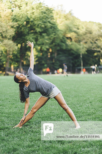 Young woman doing yoga exercise in a park