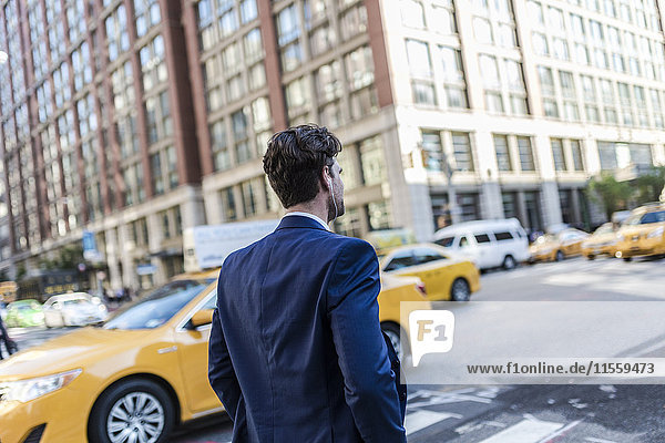 Businessman in the streets of Manhattan with yellow cab in background