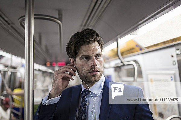 Businessman in metro using smart phone
