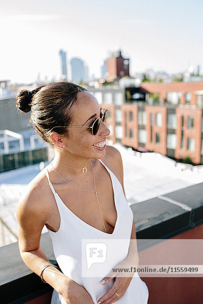 Relaxed woman standing on rooftop in Brooklyn