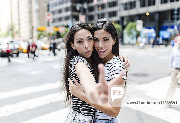 USA  New York City  Portrait von zwei schönen Zwillingsschwestern in Manhattan  die Spaß haben.