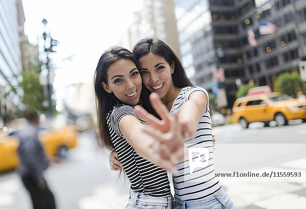 USA  New York City  Portrait von zwei schönen Zwillingsschwestern in Manhattan  die Spaß haben.