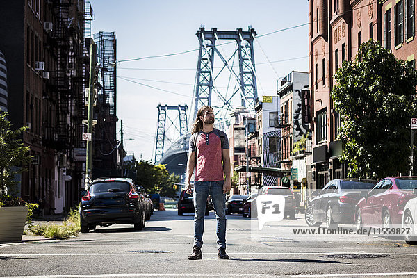 USA  New York City  Mann steht auf der Straße und schaut sich in Williamsburg  Brooklyn um.