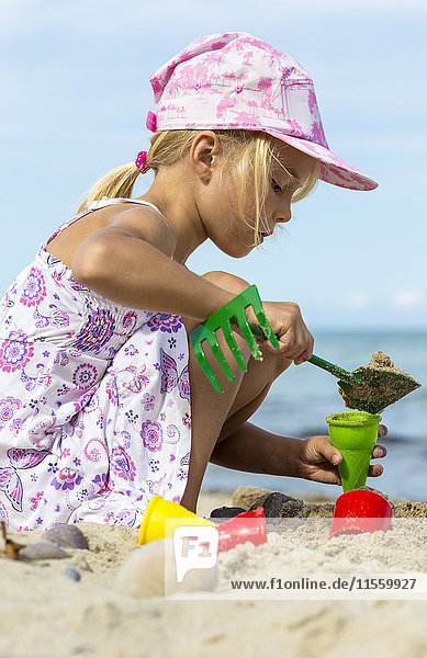 Kleines Mädchen spielt am Strand