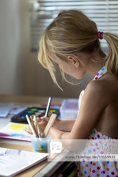 Kleine Mädchen malen mit Aquarellen