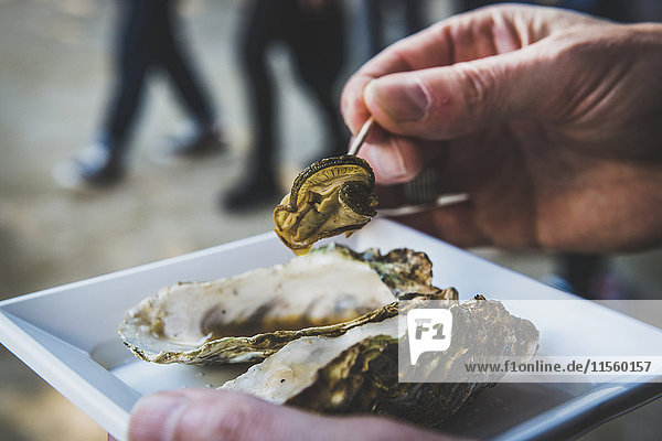 Japan  Miyajima  Mann isst gegrillte Austern