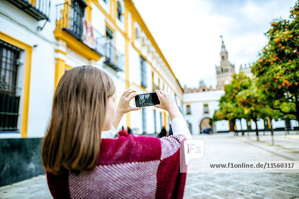 Junge Frau in Sevilla beim Fotografieren mit ihrem Selfie