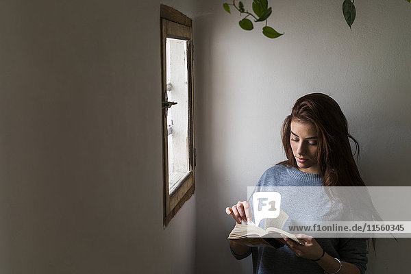 Attractive young woman reading book