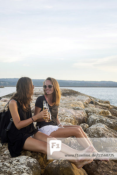 Indonesien  Bali  zwei Frauen bei einem Bier an der Küste