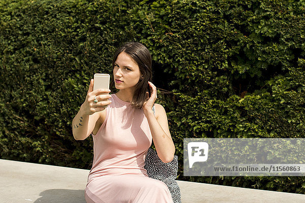 Junge Frau nimmt Selfie mit Handy