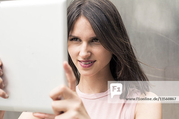 Porträt einer jungen Frau  die Selfie mit Tablette nimmt