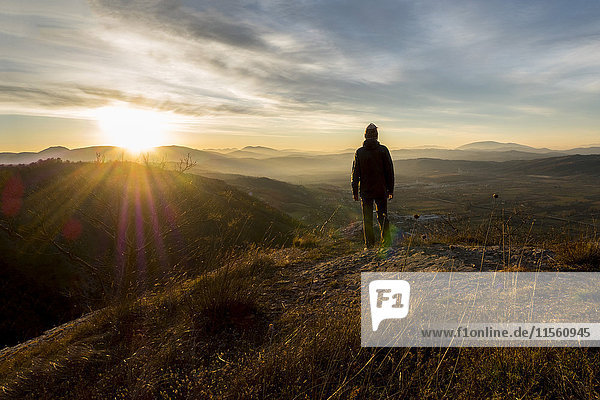 Italien  Umbrien  Gubbio  Mann beobachtet Sonnenaufgang auf dem Sibillini-Gebirge