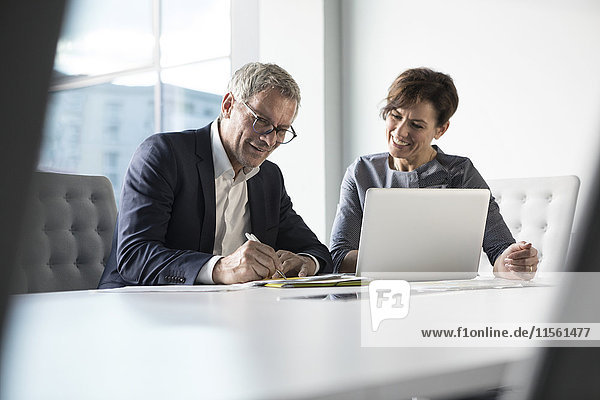 Businessman and businesswoman working together in office