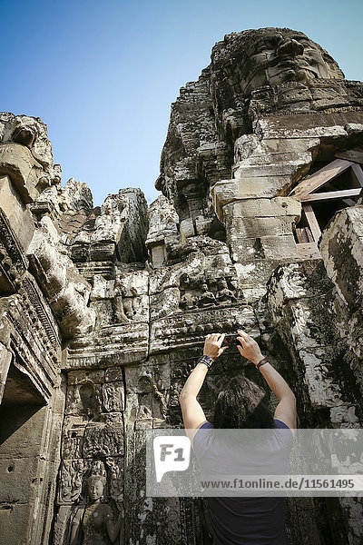 Kambodscha  Angkor Wat  Angkor Thom  Bayon-Tempel  Touristen machen Handyfoto