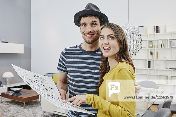 Couple with floor plan choosing furniture in furniture shop