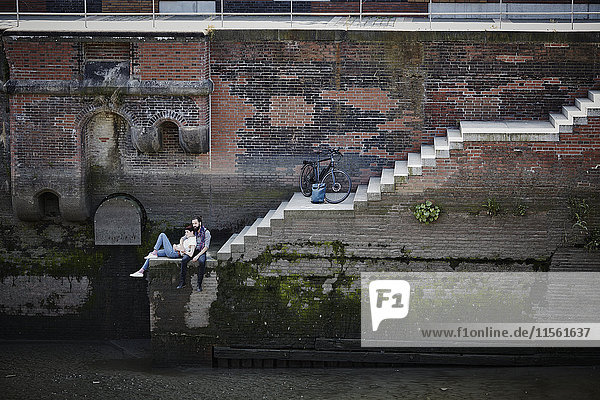 Deutschland  Hamburg  Paar mit Elektrofahrrad zum Entspannen in der Speicherstadt