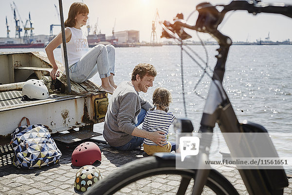 Germany  Hamburg  family having a break from a bicycle tour at River Elbe