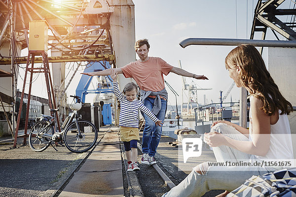 Deutschland  Hamburg  Vater und Tochter balancieren auf der Schiene am Hafen