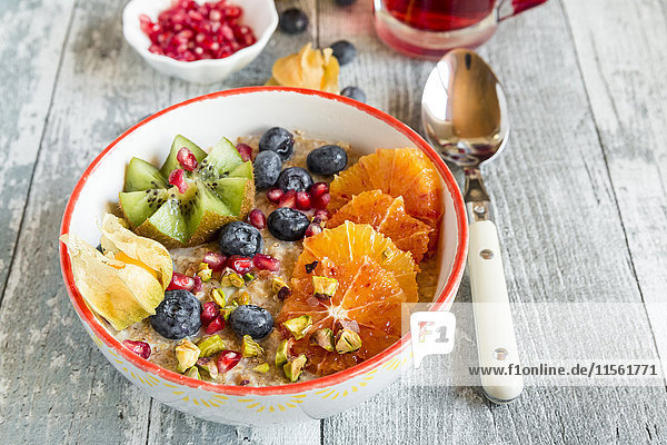Superfood-Frühstück mit Brei  Amaranth  verschiedenen Früchten und Pistazien