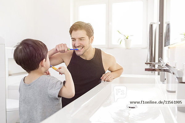 Vater und Sohn beim gemeinsamen Zähneputzen im Bad
