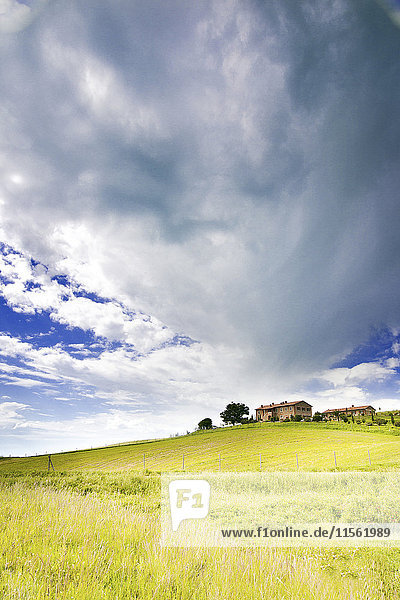 Italien  bewölkter Himmel über Häusern auf einem Hügel
