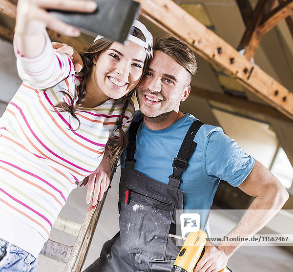 Young couple renovating their new home  taking smart phone selfies