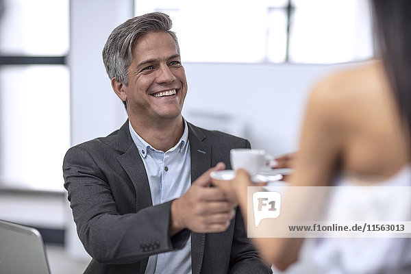 Geschäftsmann im Büro beim Kaffeetrinken