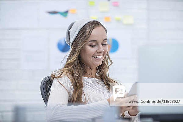 Young woman working in office  reading text messages