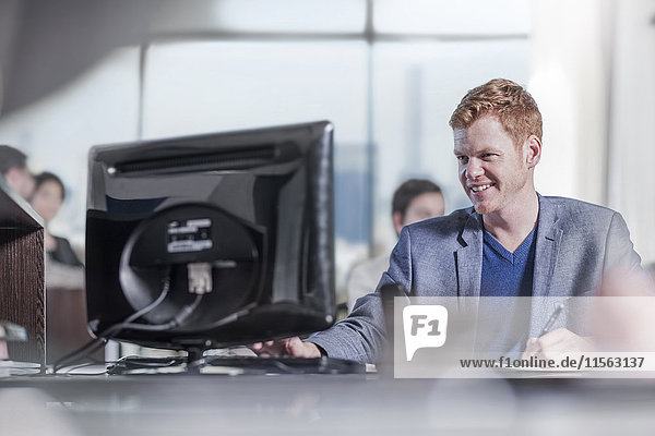 Smiling man working at desk in city office