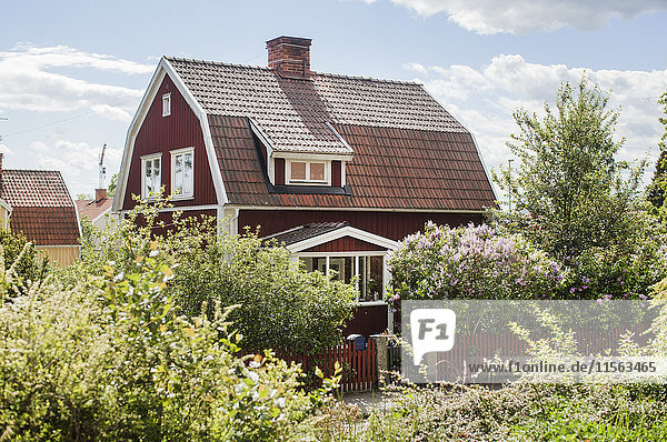 Schweden  Vastmanland  Vasteras  Holzhaus in Büschen an sonnigen Tagen