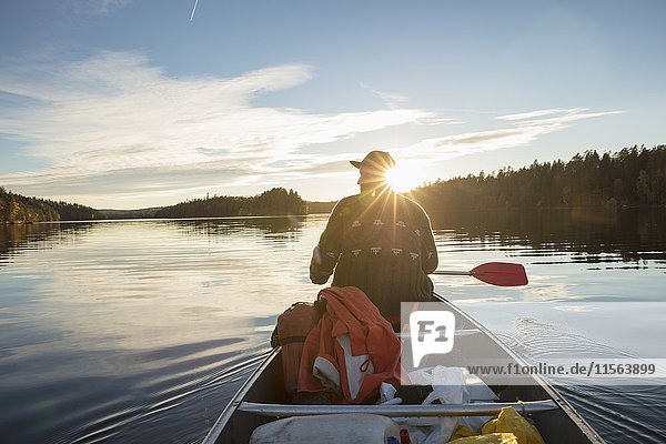 Schweden, Skane, Raslangen, Rückansicht des Mannes Paddelboot auf dem See