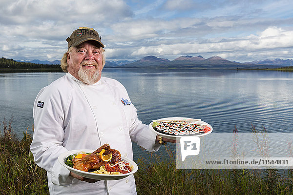 Der Chefkoch der Tikchik Narrows Lodge  Matt Spence  hält seine Peking-Ente und Sushi-Rollen am Ufer des Tikchik Lake  Wood-Tikchik State Park  Südwest-Alaska  USA