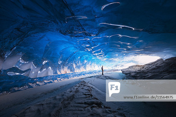 Ein Mann steht in einem Eistunnel unter dem Black Rapids Glacier  Alaska Range  Inner-Alaska  USA