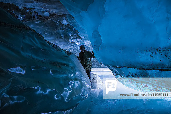 Ein Mann in einer Höhle des Canwell-Gletschers in der Alaska Range im Winter.