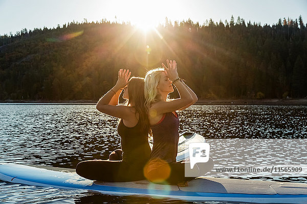 Fitness-Modelle beim Yoga auf einem Paddleboard auf dem Pinecrest Lake; Kalifornien  Vereinigte Staaten von Amerika'.